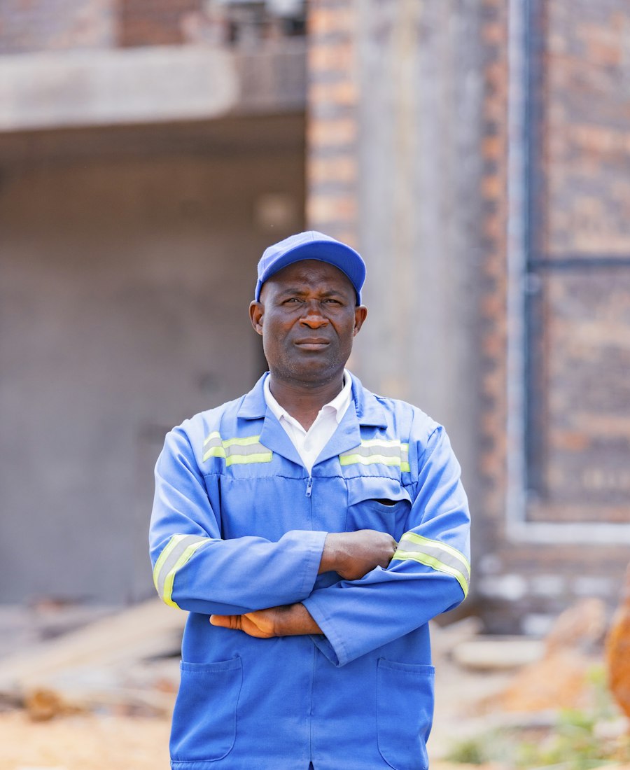 Artisan souriant en tenue de travail, bras croisés