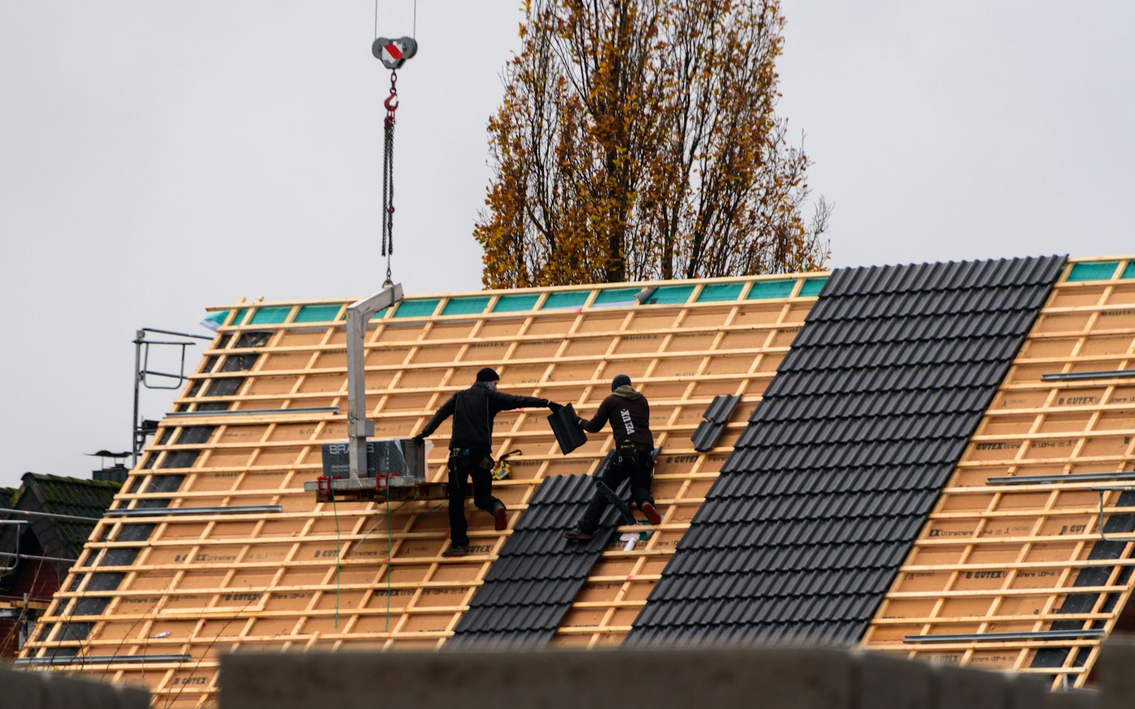 Couvreurs posant des tuiles sur une toiture neuve