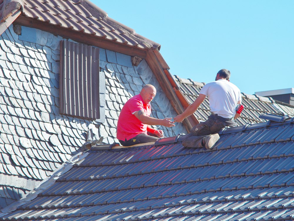 Couvreurs rénovant une toiture en ardoise